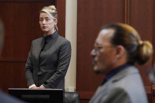 FILE - Actors Amber Heard and Johnny Depp watch as the jury leaves the courtroom for a lunch break at the Fairfax County Circuit Courthouse in Fairfax, Va., Monday, May 16, 2022.  Heard notified a Virginia court Thursday, July 21,  that she will appeal the $10.35 million judgment she was ordered to pay Depp during a high-profile defamation trial that exposed the inner workings of their troubled marriage.   (AP Photo/Steve Helber, Pool, File)