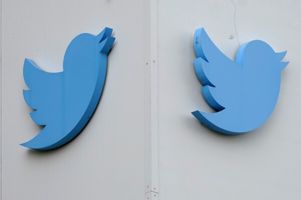 FILE - Twitter logos hang outside the company's offices in San Francisco, on Dec. 19, 2022. Australia's online safety watchdog has on Thursday, June 22, 2023, issued a legal notice to Twitter demanding an explanation of what the social media giant is doing to tackle a surge in online hate since Tesla CEO Elon Musk bought the platform. (AP Photo/Jeff Chiu, File)