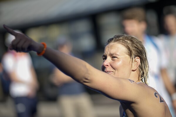 Gold medalist Sharon Van Rouwendaal, of the Netherlands, celebrates after crossing the finish line at the end of the marathon swimming women's 10km competition at the 2024 Summer Olympics, Thursday, Aug. 8, 2024, in Paris, France. (AP Photo/David Goldman)