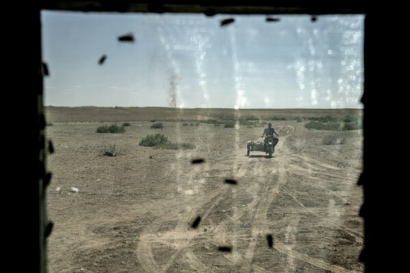 A man rides to his home through the area of the dried-up Aral Sea in Uzbekistan, Saturday, June 24, 2023. (AP Photo/Ebrahim Noroozi)