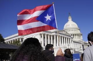 FILE - A woman waves a Puerto Rico flag during a news conference on Puerto Rican statehood on Capitol Hill in Washington, March 2, 2021. As Puerto Rico emerges from a drawn-out bankruptcy process, a federal control board that oversees the island’s finances announced on April 5, 2023 that it will focus on growing the U.S. territory’s economy. (AP Photo/Patrick Semansky, File)