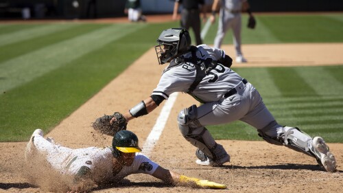 Oakland Athletics' Tyler Wade, left, slides safely across home plate with the winning run ahead of the tag by Chicago White Sox catcher Carlos Pérez (36) during the tenth inning of a baseball game, Saturday, July 1, 2023, in Oakland, Calif. The A's won 7-6. (AP Photo/D. Ross Cameron)