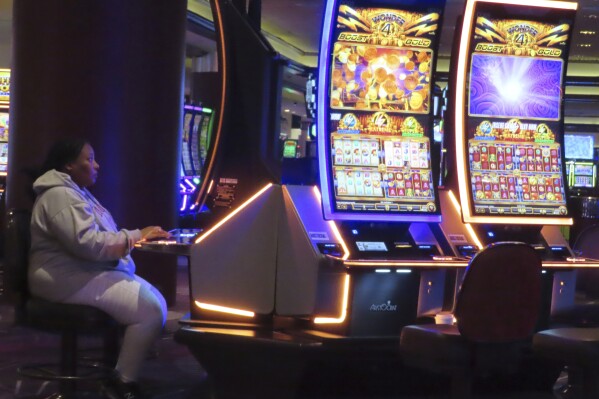 A gambler plays a slot machine at Harrah's casino in Atlantic City, N.J., on Sept. 29, 2023. New Jersey's casinos, racetracks that take sports bets and their online partners won over $423 million in October, up 6.6% from a year earlier, according to figures released Friday, Nov. 17, by state gambling regulators. (AP Photo/Wayne Parry)