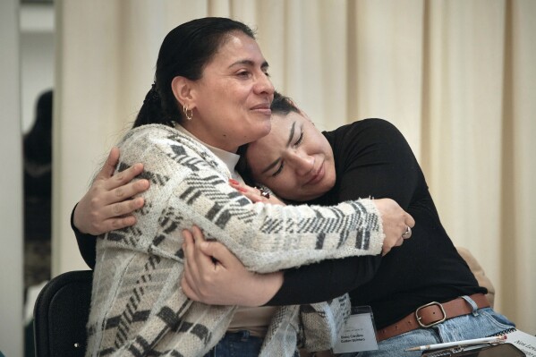 Claudia Saenz, left, and Diana Carolina Guillen hug and cry during a sexual harassment prevention class for nannies and housekeepers on Saturday, April 27, 2024, in the Brooklyn borough of New York. Nannies, housekeepers, and home care workers are excluded from many federal workplace protections in the United States, and the private, home-based nature of the work means abuse tends to happen behind closed doors. (AP Photo/Andres Kudacki)