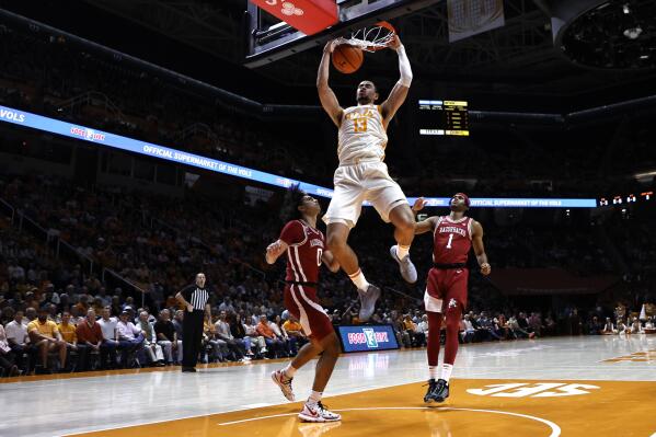 Tennessee forward Olivier Nkamhoua (13) dunks the ball over Arkansas guard Anthony Black (0) during the first half of an NCAA college basketball game, Tuesday, Feb. 28, 2023, in Knoxville, Tenn. (AP Photo/Wade Payne)