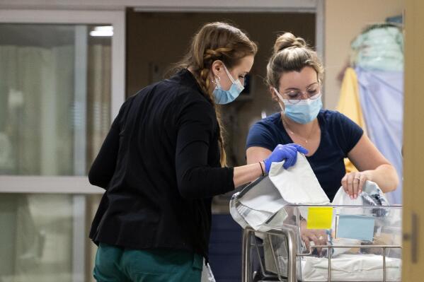 In a photo provided by the University of Vermont Health Network, licensed nursing assistant Jordan Bushy, right, and a student nurse care for newborns at the University of Vermont Children’s Hospital in Burlington, Vt., Friday, April 28, 2023. Research led by Dr. Leslie Young of the children’s hospital has found that babies born to opioid users had shorter hospital stays and needed less medication when their care emphasized parent involvement, skin-to-skin contact and a quiet environment. (Ryan Mercer/University of Vermont Health Network via AP)