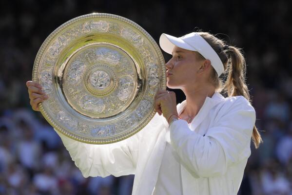 Kazakhstan's Elena Rybakina kisses the trophy as she celebrates after beating Tunisia's Ons Jabeur to win the final of the women's singles on day thirteen of the Wimbledon tennis championships in London, Saturday, July 9, 2022. (AP Photo/Kirsty Wigglesworth)