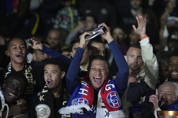 PSG's Kylian Mbappe, centre, celebrates with his teammates PSG's French League One title after the French League One soccer match between Paris Saint-Germain and Toulouse at the Parc des Princes stadium in Paris, Sunday, May 12, 2024. (AP Photo/Christophe Ena)