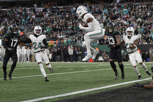 Miami Dolphins safety Jevon Holland (8) catches a Hail Mary pass at the 1-yard line before running it back for a touchdown against the New York Jets during the second quarter of an NFL football game, Friday, Nov. 24, 2023, in East Rutherford, N.J. (AP Photo/Adam Hunger)