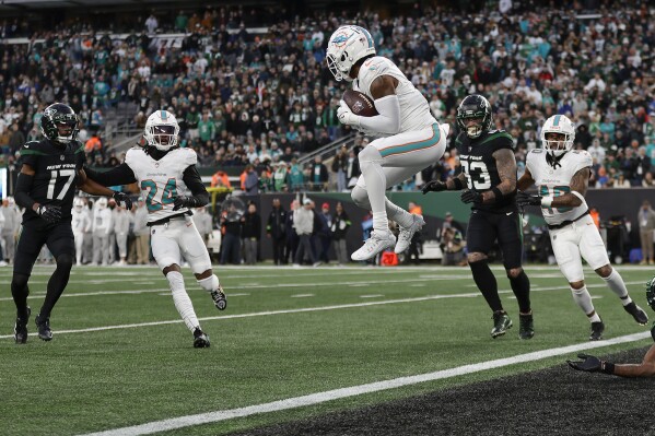 Miami Dolphins safety Jevon Holland (8) catches a Hail Mary pass at the 1-yard line before running it back for a touchdown against the New York Jets during the second quarter of an NFL football game, Friday, Nov. 24, 2023, in East Rutherford, N.J. (AP Photo/Adam Hunger)