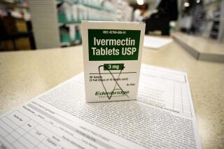 A box of ivermectin is shown in a pharmacy as pharmacists work in the background, Thursday, Sept. 9, 2021, in Ga. At least two dozen lawsuits have been filed around the U.S., many in recent weeks by people seeking to force hospitals to give their COVID-stricken loved ones ivermectin, a drug for parasites that has been promoted by conservative commentators as a treatment despite a lack of conclusive evidence that it helps people with the virus. (AP Photo/Mike Stewart)