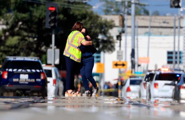 Two people hug on Younger Avenue outside the scene of a shooting in San Jose, Calif., on Wednesday, May, 26. 2021. An employee opened fire Wednesday at a California railyard serving Silicon Valley, killing multiple people before ending his own life, authorities said. The suspect was an employee of the Valley Transportation Authority, which provides bus, light rail and other transit services throughout Santa Clara County, the most populated county in the Bay Area, authorities said. (Randy Vazquez/Bay Area News Group via AP)
