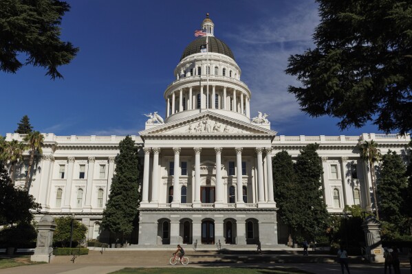 People walk around the California State Capitol on Monday, Aug. 5, 2024, in Sacramento, Calif. (AP Photo/Juliana Yamada, File)