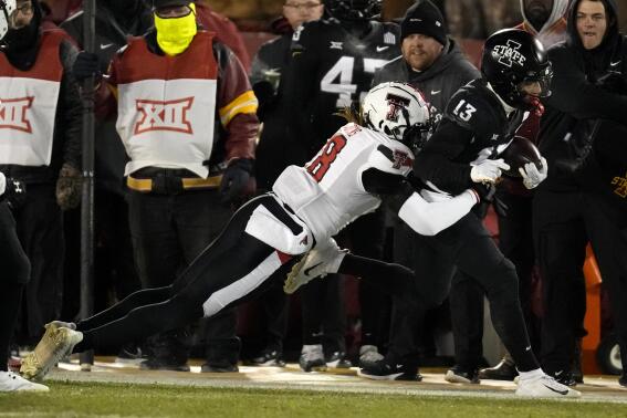 Iowa State wide receiver Jaylin Noel (13) tries to break a tackle by Texas Tech defensive back Tyler Owens (18) after catching pass during the first half of an NCAA college football game, Saturday, Nov. 19, 2022, in Ames, Iowa. (AP Photo/Charlie Neibergall)