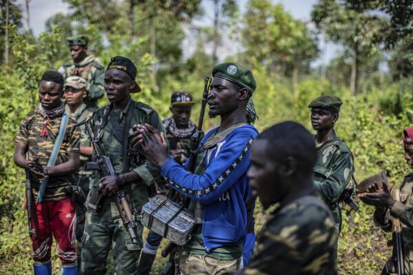 Armed militiamen gather near Rutshuru, 70 kms (45 miles) north of Goma, Democratic Republic of Congo,Wednesday June 22, 2022. Earlier in the week, East Africa's leaders have responded to the threat of war between Rwanda and Congo by instructing a new regional force to deploy in eastern Congo and ordering an immediate cease-fire. A statement after the meeting in Kenya's capital does not give details on the date of deployment of the force or its composition. (AP Photo/Moses Sawasawa)