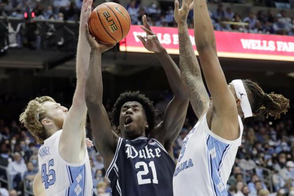 Duke forward A.J. Griffin (21) drives to the hoop between North Carolina forwards Brady Manek (45) and Armando Bacot, right, during the second half of an NCAA college basketball game Saturday, Feb. 5, 2022, in Chapel Hill, N.C. (AP Photo/Chris Seward)