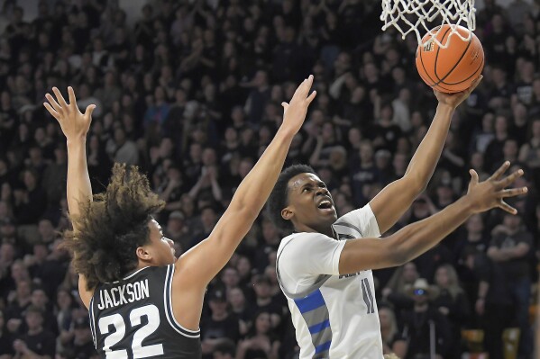 Air Force guard Byron Brown (11) drives to the basket as Utah State guard Javon Jackson (22) defends during the first half of an NCAA college basketball game Friday, March. 1, 2024, in Logan, Utah. (Eli Lucero/The Herald Journal via AP)