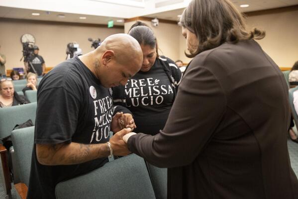 John Lucio, with his wife, Michelle Lucio, prays with Jennifer Allmon, right, Executive Director of the Texas Catholic Conference of Bishops, before a hearing by the Interim Study Committee on Criminal Justice Reform about his mother, death row inmate Melissa Lucio, at the Capitol, in Austin, Texas, on Tuesday, April 12, 2022. A bipartisan majority of the Texas House of Representatives is calling for clemency for Melissa Lucio who was convicted of capital murder in 2008 after the death of her daughter. (Jay Janner/Austin American-Statesman via AP)