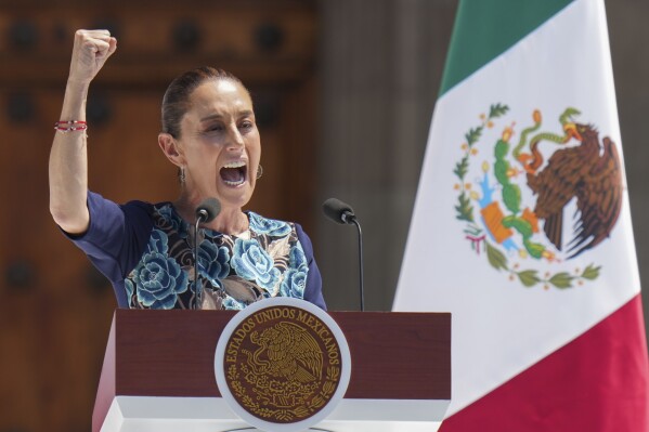 President Claudia Sheinbaum gestures to supporters at a rally she convened to welcome U.S. President Donald Trump's decision to postpone tariffs on Mexican goods for one month at the Zocalo, Mexico City's main square, Sunday, March 9, 2025. (AP Photo/Eduardo Verdugo)