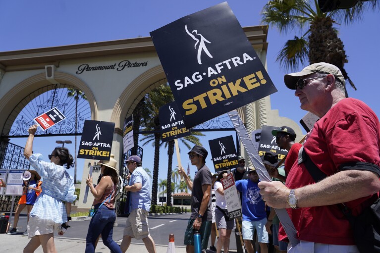 Striking writers and actors picket outside Paramount studios in Los Angeles on Friday, July 14, 2023. This marks the first day actors formally joined the picket lines, more than two months after screenwriters began striking in their bid to get better pay and working conditions. (AP Photo/Chris Pizzello)