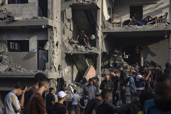 Palestinians look for survivors of the Israeli bombardment in the Maghazi refugee camp in the Gaza Strip, Sunday, Nov. 5, 2023. (AP Photo/Fatima Shbair)