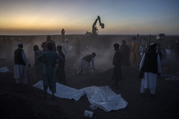 Afghans bury hundreds of people killed in an earthquake at a burial site, outside a village in Zenda Jan district in Herat province, western of Afghanistan, Monday, Oct. 9, 2023. Saturday's deadly earthquake killed and injured thousands when it leveled an untold number of homes in Herat province. (AP Photo/Ebrahim Noroozi)