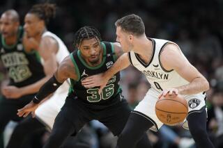 Marcus Smart (36), base de los Celtics de Boston, defiende a Goran Dragic, de Eslovenia, de los Nets de Brooklyn, en la primera mitad del juego 1 de la serie de playoffs de la Conferencia Este de la NBA, el domingo 17 de abril de 2022, en Boston. Los Celtics ganaron 115-114. (AP Foto/Steven Senne)