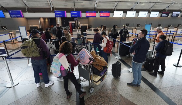 Travelers queue up for the check-in counter for Aeromexico Airlines Tuesday, April 16, 2024, in Denver International Airport in Denver. (AP Photo/David Zalubowski)