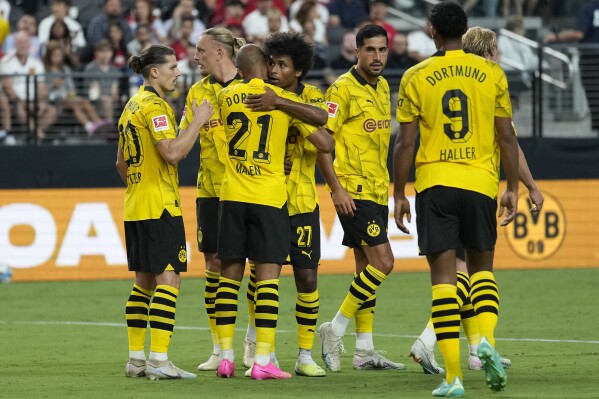 FILE - Borussia Dortmund players celebrate after Donyell Malen (21) scored against Manchester United during the first half of an international friendly soccer match Sunday, July 30, 2023, in Las Vegas. After coming so close to ending Bayern Munich’s hegemony of the Bundesliga last season, Borussia Dortmund needs to channel its disappointment into a renewed effort. But the team’s best player, Jude Bellingham, has departed for Real Madrid and Raphaël Guerreiro has switched to Bayern. It’s a tall order for their replacements to do any better. (AP Photo/John Locher, File)