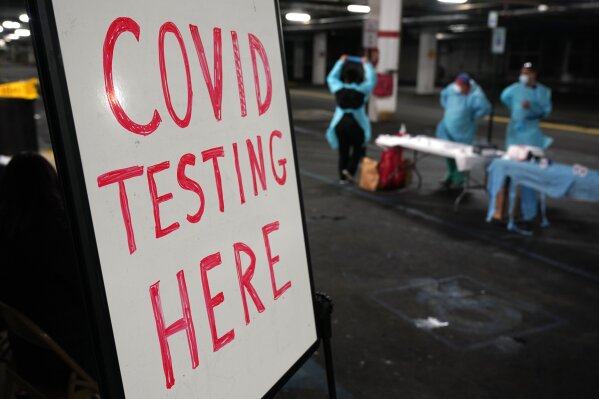 A sign indicating a COVID-19 testing site is displayed inside a parking garage in West Nyack, N.Y., Monday, Nov. 30, 2020. The site was only open to students and staff of Rockland County schools in an effort to test enough people to keep the schools open for in-person learning. (AP Photo/Seth Wenig)