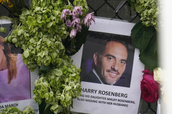 FILE - In this June 29, 2021, file photo, an image of Harry Rosenberg, missing since an oceanfront condo building collapsed in Surfside, Fla., hangs on a fence as part of a makeshift memorial. After losing his wife to cancer and his parents to COVID-19, Rosenberg’s new home came with the promise of a fresh start. His daughter, Malky Weisz. and her husband, Benny Weisz, had just arrived for a visit and are also missing. (AP Photo/Gerald Herbert, File)