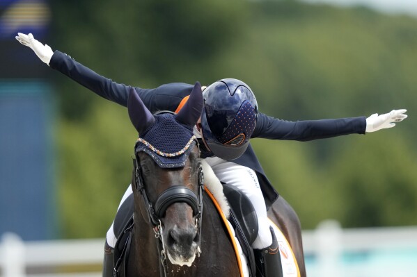 Netherlands' Dinja van Liere celebrates as she rides Hermes during the dressage team Grand Prix final at the 2024 Summer Olympics, Saturday, Aug. 3, 2024, in Versailles, France. (AP Photo/Mosa'ab Elshamy)