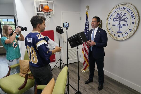 Miami Mayor Francis Suarez, right, records a video in his office, Friday, Oct. 29, 2021, at City Hall in Miami. Suarez is hoping to easily secure a second term on Tuesday, Nov 2, 2021. His reelection campaign has offered an opportunity to show he can raise millions as he seeks to elevate his profile at a national level. (AP Photo/Wilfredo Lee)