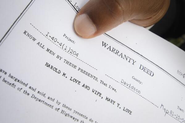 Tennessee State Rep. Harold Love, Jr. holds a copy of the deed to his family's former house on the north side of the city, Monday, July, 19, 2021, in Nashville, Tenn. Love Jr.'s father, a Nashville city councilman, was forced to sell his family home here to make way for the highway, but put up a fight in the 1960s against the rerouting of Interstate 40 because he believed it would stifle and isolate Nashville's Black community. Love Jr. is now part of a group pushing to build a cap across the highway that creates a community space to help reunify the city. (AP Photo/John Amis)