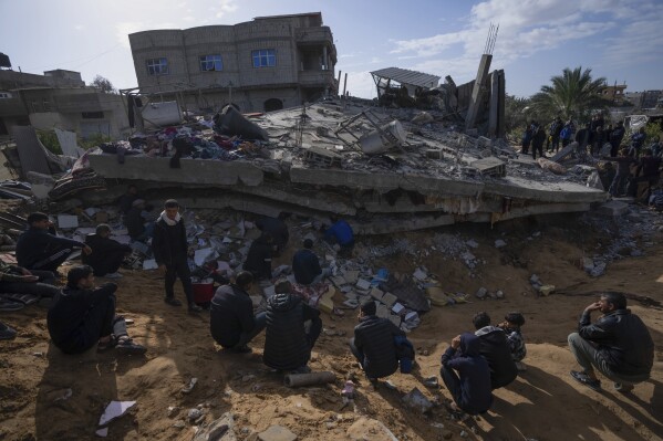 文件——2024年3月4日，加沙地带拉法，巴勒斯坦人在以色列空袭中摧毁的一栋住宅楼废墟中搜寻尸体和幸存者。美联社对加沙卫生部数据的分析发现，在以色列-哈马斯战争中被杀害的巴勒斯坦妇女和儿童的比例似乎急剧下降。以色列因加沙前所未有的平民伤亡而受到国际社会的严厉批评。（美联社照片/Fatima Shbair，文件）