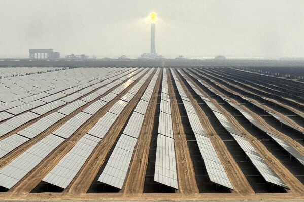 Solar panels at Mohammed bin Rashid Al Maktoum Solar Park and its solar tower are visible, in Dubai, United Arab Emirates, Nov. 9, 2023. The solar park represents a pledge of billions of dollars by this city-state to reach its goal of becoming carbon-neutral by 2050. (AP Photo/Kamran Jebreili)