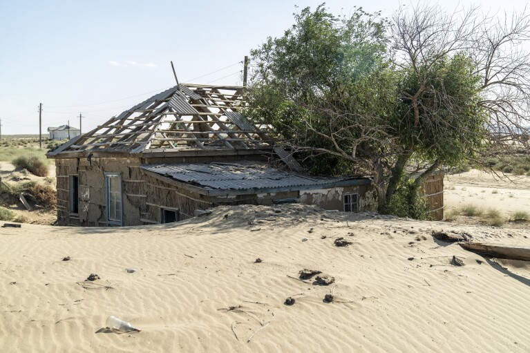 The remains of a house destroyed by sand sits near the dried-up Aral Sea, near Aralsk, Kazakhstan, Monday, July 3, 2023. (AP Photo/Ebrahim Noroozi)