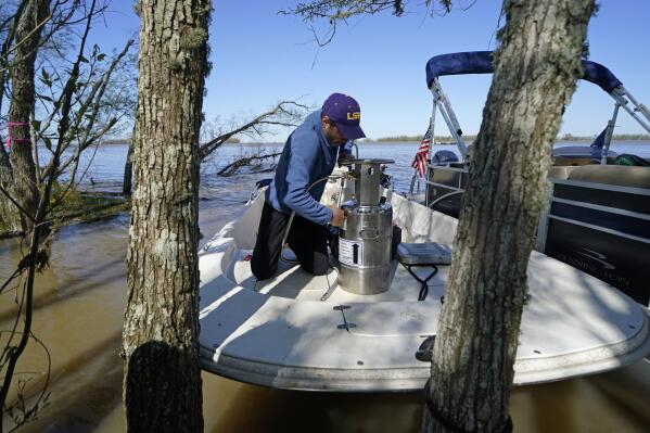 Andre Rabay, research scientist for the LSU Department of Oceanography and Coastal Science prepares a canister of liquid nitrogen that he will use to freeze samples of the ground on Mike Island, part of the Wax Lake Delta in the Atchafalaya Basin, in St. Mary Parish, La., Friday, April 2, 2021. NASA is using high-tech airborne systems along with boats and mud-slogging work on islands for a $15 million study of these two parts of Louisiana's river delta system.  (AP Photo/Gerald Herbert)