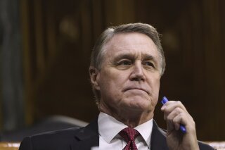 FILE - In this Sept. 24, 2020, file photo Sen. David Perdue, R-Ga., listens during the Senate's Committee on Banking, Housing, and Urban Affairs hearing on Capitol Hill in Washington. With in-person campaigning dampened by the coronavirus, advertising has taken on even greater importance in Perdue’s race against Democrat Jon Ossoff. (Drew Angerer/Pool via AP, File)
