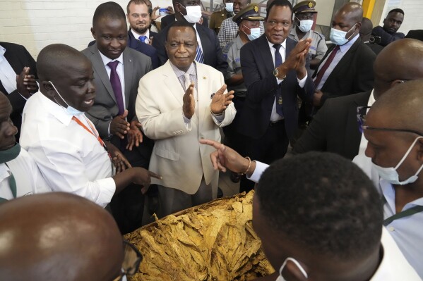 FILE -Zimbabwean Deputy President Constantino Chiwenga, centre, attends the official opening of the tobacco marketing season in Harare, Zimbabwe, Wednesday, March, 8, 2023. Zimbabwe’s powerful vice president said the government will block a university scholarship for young LGBTQ+ people, a move that human rights groups described Friday, Feb. 16, 2024, as a perpetuation of the African country's homophobic practices. (AP Photo/Tsvangirayi Mukwazhi, File)