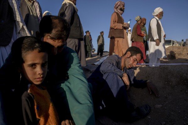 An Afghan man mourns next to the grave of his wife who died due to an earthquake, in Zenda Jan district in Herat province, western of Afghanistan, Monday, Oct. 9, 2023. Saturday's deadly earthquake killed and injured thousands when it leveled an untold number of homes in Herat province. (AP Photo/Ebrahim Noroozi)