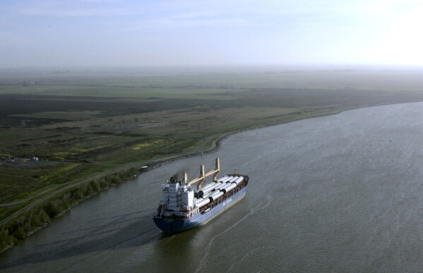 FILE - A ship moves through the Sacramento-San Joaquin River Delta near Bethel Island, Calif., March 12, 2008. California Gov. Gavin Newsom's administration now says it will cost more than $20 billion to build a giant tunnel so the state can catch more water when it rains and store it to better prepare for longer droughts caused by climate change. (AP Photo/Rich Pedroncelli, File)