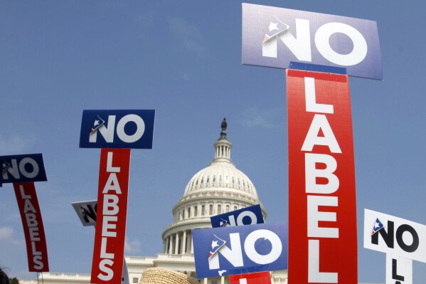 FILE - People with the group No Labels hold signs during a rally on Capitol Hill in Washington, July 13, 2013. The political organization No Labels has contemplated requiring a donation of at least $100 in order to cast a ballot at the group's upcoming nominating convention according to documents obtained by The Associated Press. (AP Photo/Jacquelyn Martin, File)