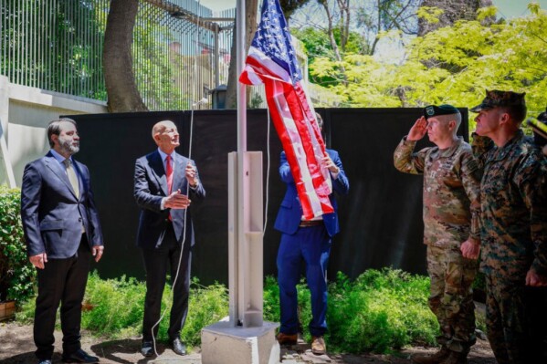 In this photo released by the Syrian official news agency SANA, U.S. Ambassador to Turkey and Special Envoy to Syria Tom Barrack raises the American flag at the U.S. ambassador's residence in Damascus, Syria, Thursday, May 29, 2025. (SANA via AP)