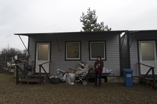 50-year-old Natalia Zhyvohliad, a displaced person from Nova Petrivka in the Zaporizhzhia region of Ukraine, is pictured standing outside her temporary modular house in Kolomyya, Ivano-Frankivsk region on Feb. 13, 2024. (AP Photo/Vasilisa Stepanenko)