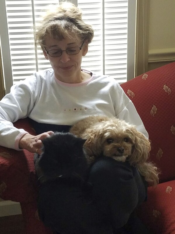 This Jan. 28, 2017 photo provided by Rod Azama shows his wife Susan relaxing with her dog Sunny at home in Silver Spring, Md. Eight states and Washington D.C. allow physician-assisted death for certain terminally ill patients, like Susan Azama., but only for their own residents. Vermont and Oregon permit any qualifying American to travel to their state for the practice, so the Maryland resident traveled to Oregon. (Rod Azama via AP)
