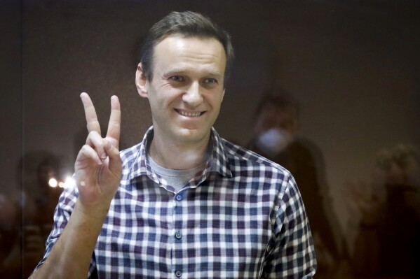 FILE - Russian opposition leader Alexei Navalny gestures as he stands in a cage in the Babuskinsky District Court in Moscow, Russia, Saturday, Feb. 20, 2021. A memoir Alexei Navalny began working on in 2020 will be published this fall. 