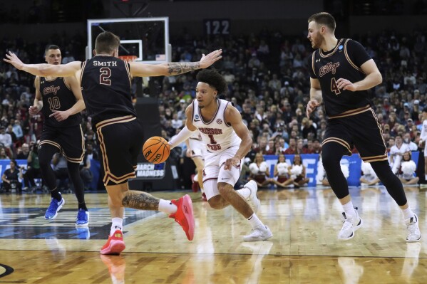 Alabama guard Mark Sears (1) drives between Charleston guards Reyne Smith (2) and Bryce Butler (4) during the first half of a first-round college basketball game in the men's NCAA Tournament in Spokane, Wash., Friday, March 22, 2024. (AP Photo/Ted S. Warren)