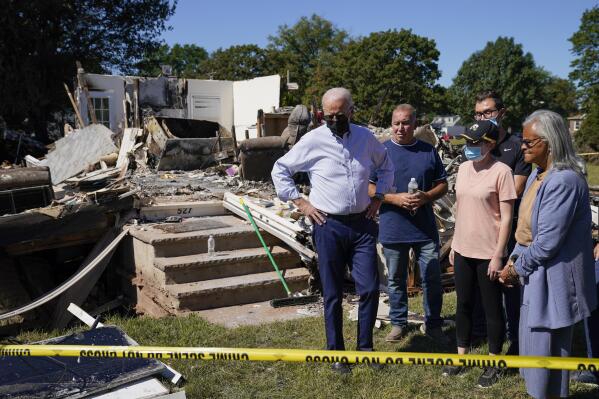 FILE - In this Sept. 7, 2021, file photo President Joe Biden tours a neighborhood impacted by Hurricane Ida in Manville, N.J. Rep. Bonnie Watson Coleman, D-N.J., looks on at right. Surveying damage from California wildfires to hurricane-induced flooding in Louisiana and New York Biden said America must get serious about the “code red” danger posed by global warming. (AP Photo/Evan Vucci, File)