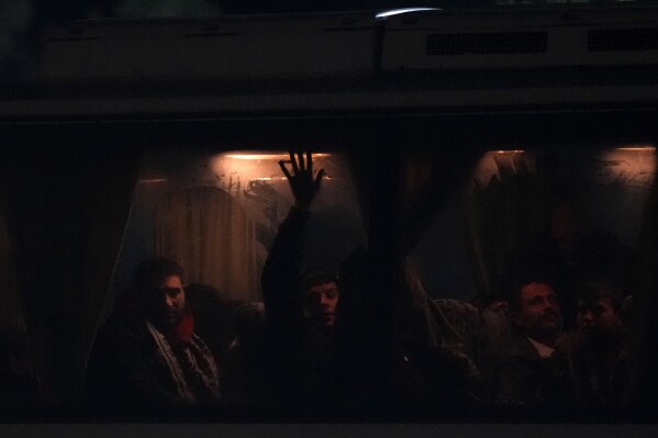 Migrants from Syria seat on a bus from Ayia Napa to the Pournara migrant reception center in Kokkinotrimithia outside of capital Nicosia, Cyprus, Wednesday, Jan. 24, 2024. Officials say at least four people have been hospitalized after Cypriot police rescued 60 Syrian migrants found aboard a rickety wooden boat off the island nation's souteastern tip. They have been at sea for six days. Helicopters flew the three children and one adult to a hospital after a passing merchant ship notified Cypriot authorities of the boat's presence early Wednesday. (AP Photo/Petros Karadjias)